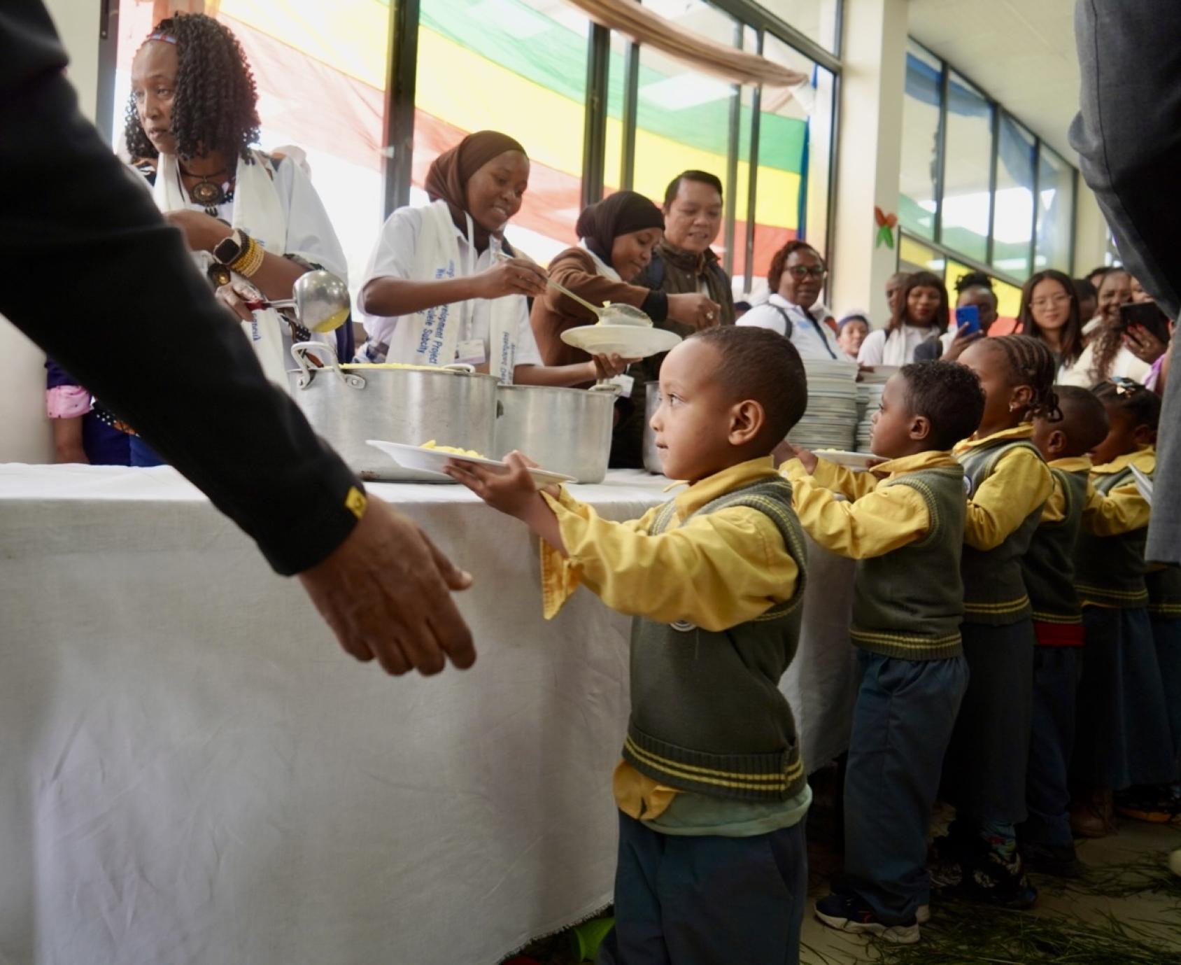 A group of children being served food