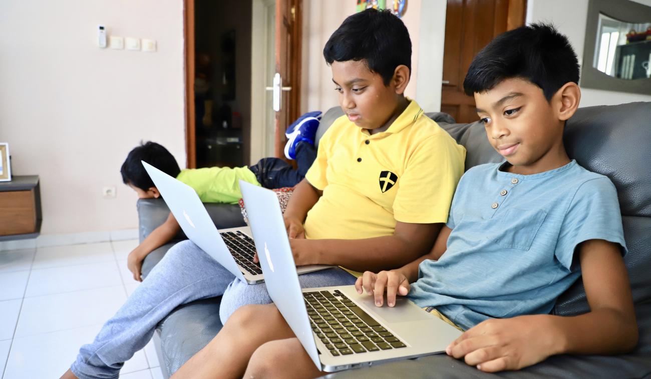 Nasaina, un niño de 12 años, y su hermano Antso, de 8, trabajan con sus ordenadores portátiles, en su casa de Brazzaville.