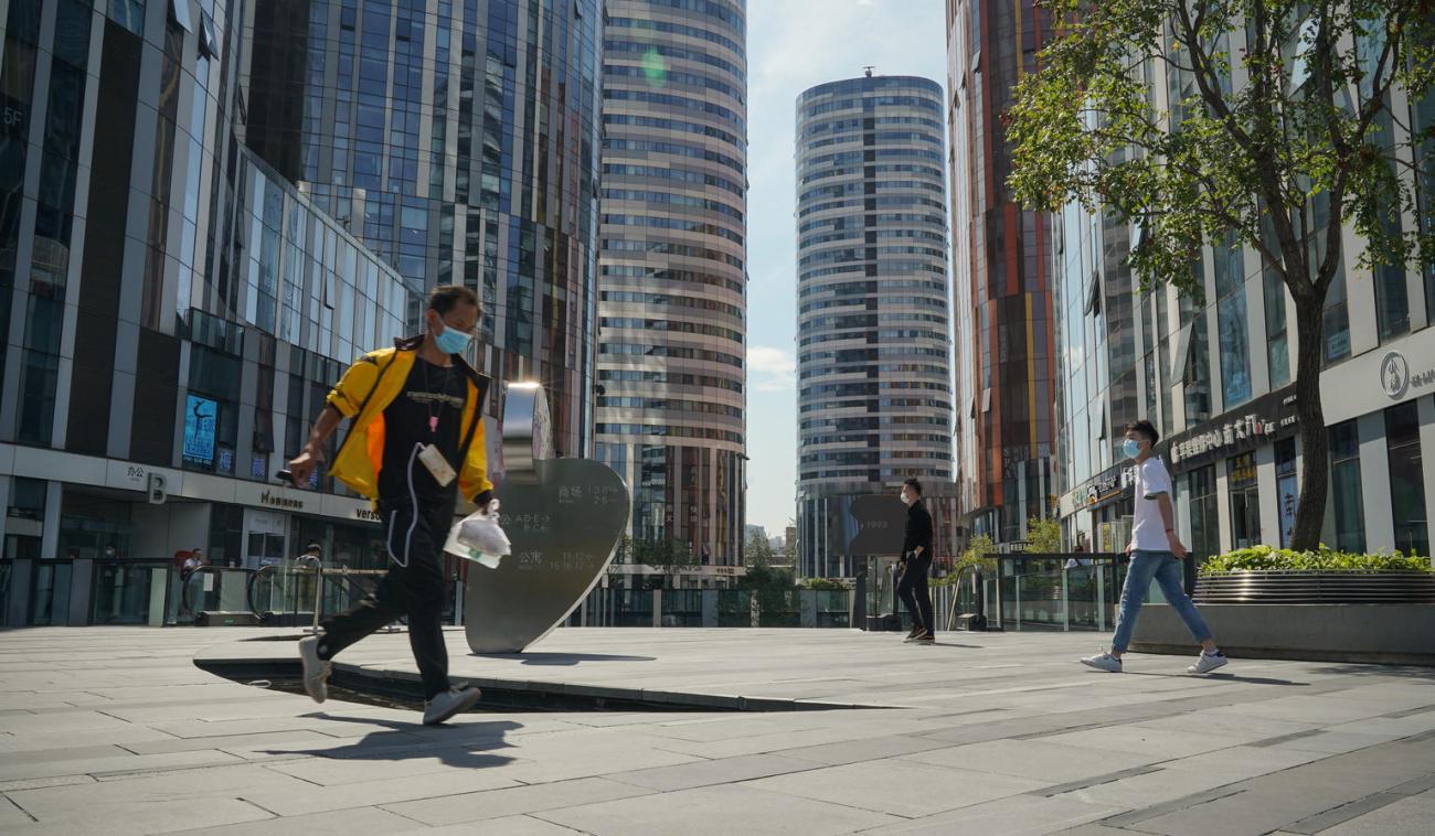 A delivery man wearing a face mask runs to deliver food in Beijing, China.