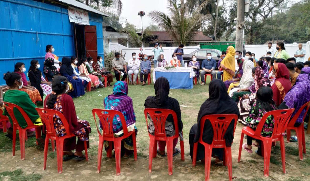 一大群戴着面罩的人坐成一圈，中间有一个人在说话。 