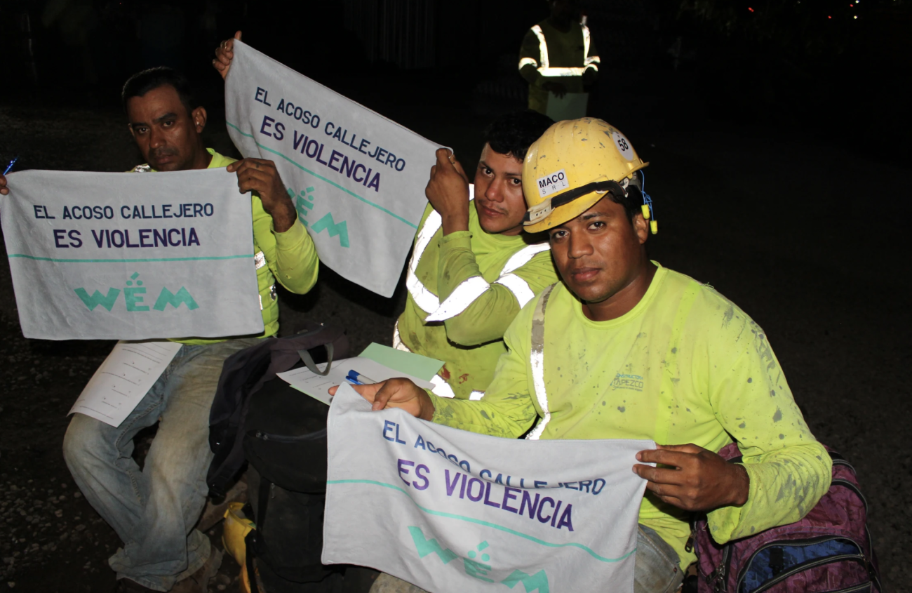 三名身穿黄衫的男子举着毛巾，上面写着“在街上叫猫叫是对妇女的暴力”。