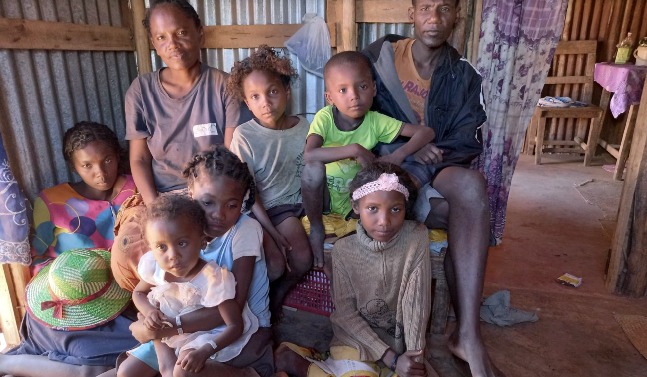 Fagnosea and Masy and their family sit together inside their home.