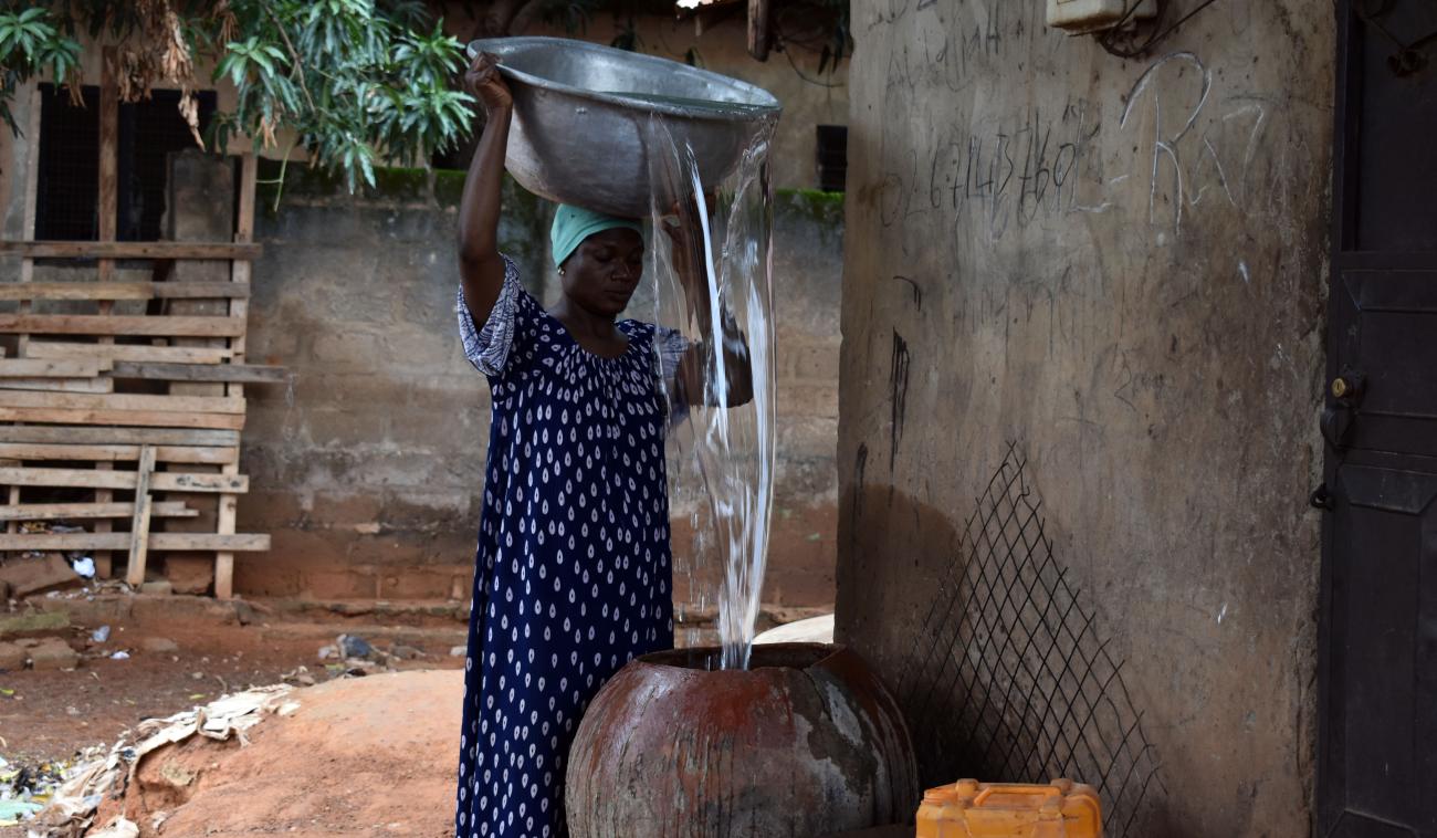 Adisa Abdul Rhaman vierte agua en su olla fuera de su casa.