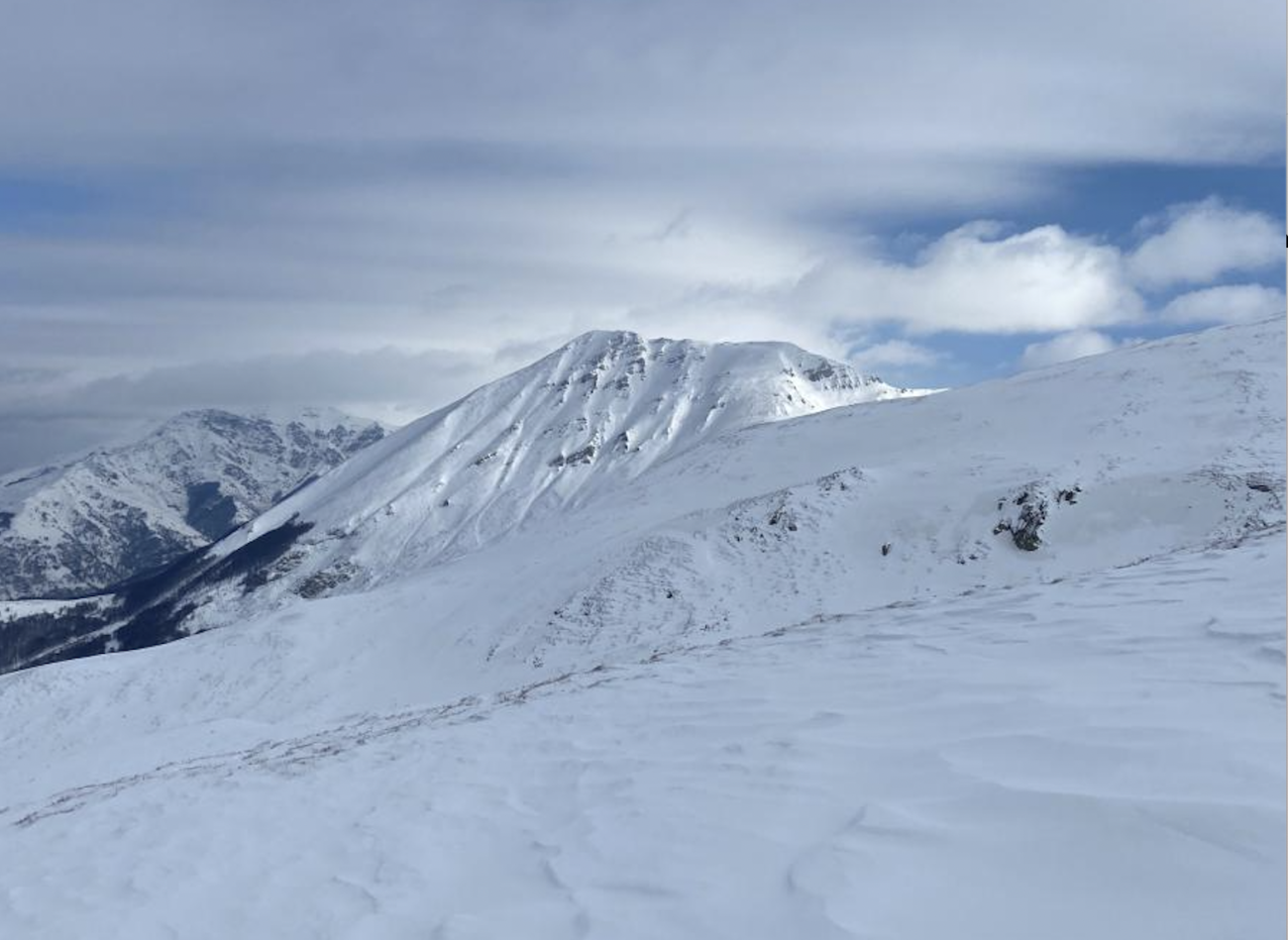 An image of a snowy mountaintop on a cloudy day.