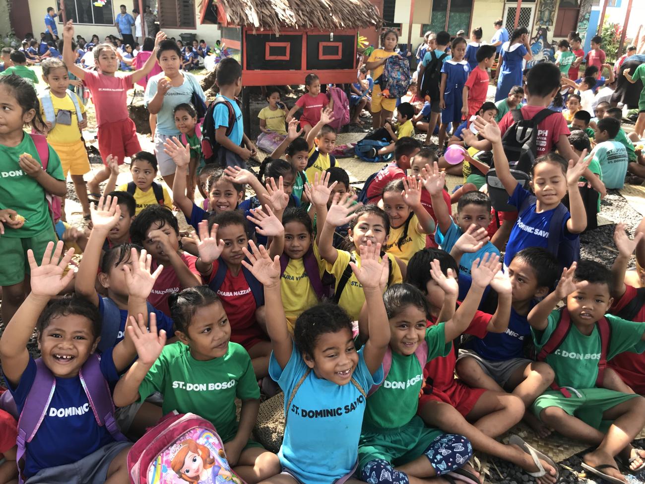 穿着五颜六色衣服的儿童举起双手。