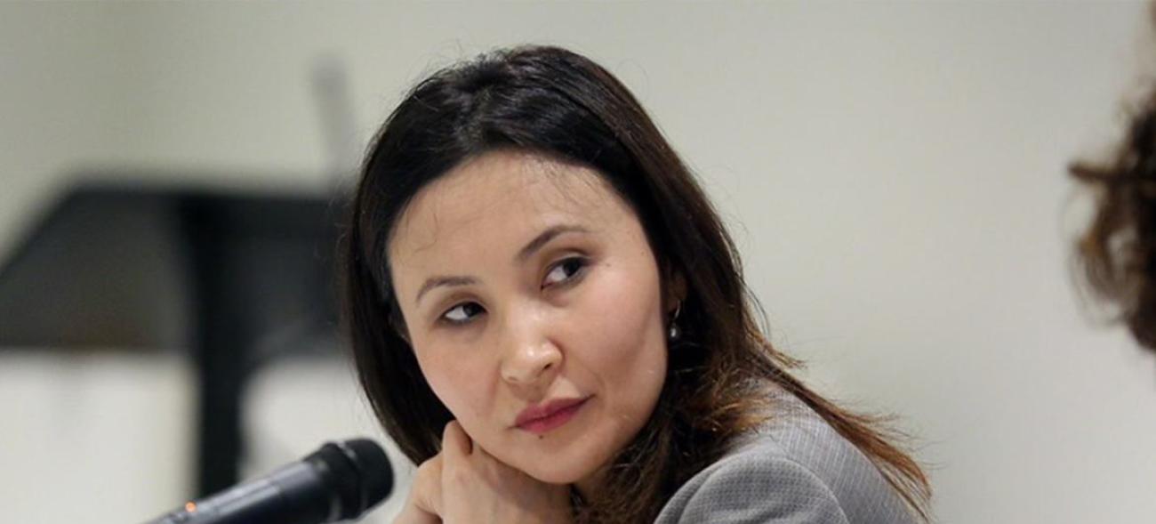 Крупный план лица женщины, сидящей перед микрофоном.