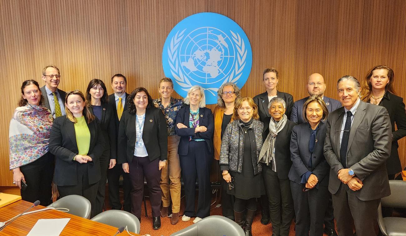 People in suits standing in front of the UN logo