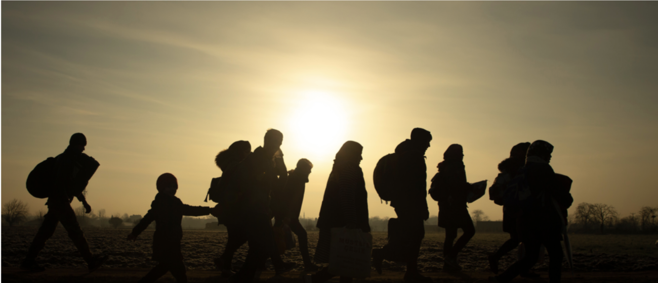 Женщины, мужчины и дети, нагруженные вещами идут к границе, на фоне закатного солнца.Huseyin Aldemir / Shutterstock.com Мигранты идут к пограничному переходу Пазаркуле (Турция) и Кастаниес (Греция) в Эдирне, Турция, 1 марта 2020 года. Фото