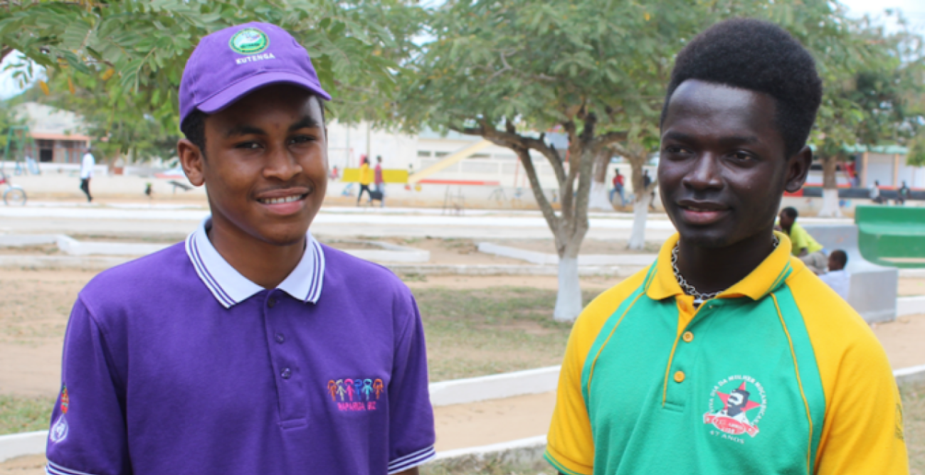 Two young men, one in a purple shirt and matching cap and another in a green and yellow shirt in Mozambique