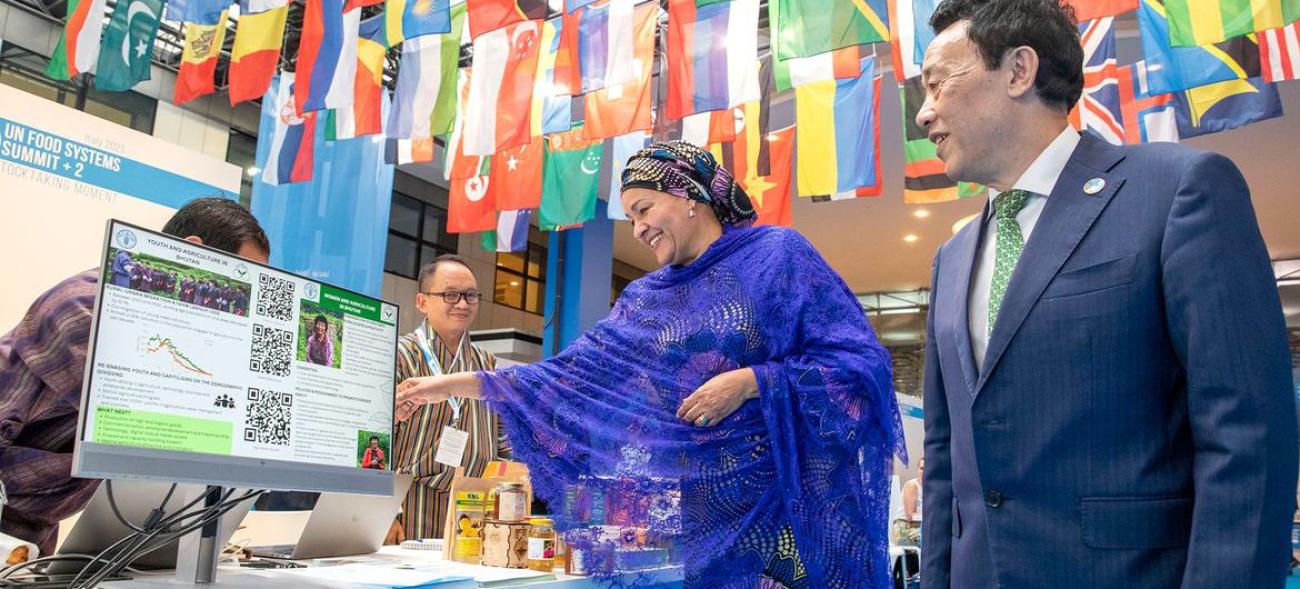 The deputy head of the UN talks to people as she visits a food innovation booth.