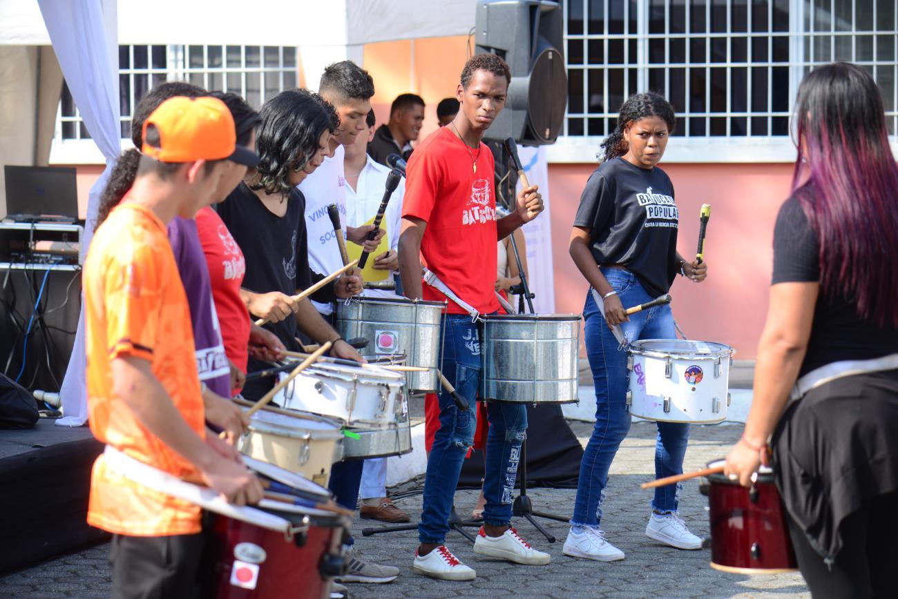 A popular youth group plays drums and music outside.