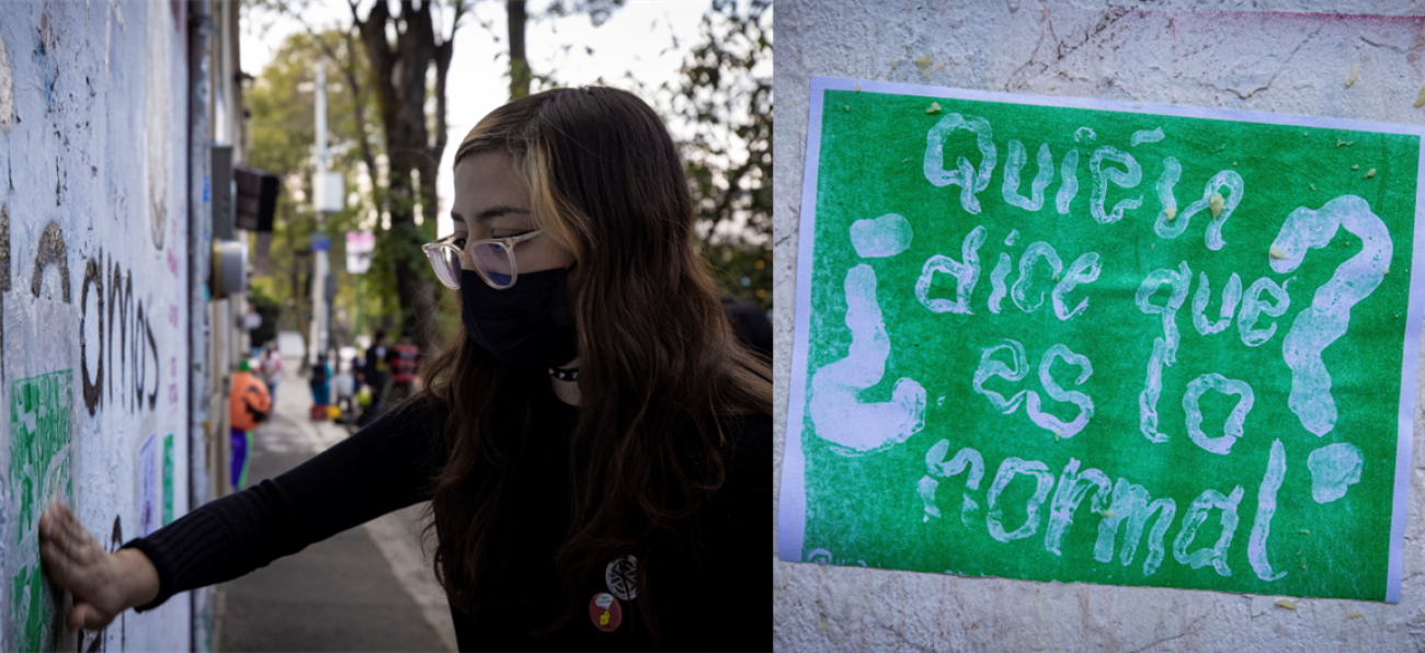 A woman in a black dress and a black mask draws graffiti on a wall.
