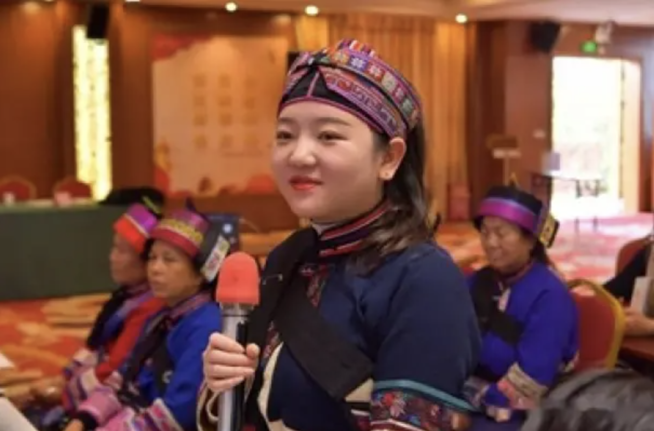 傣族妇女手持话筒准备发言