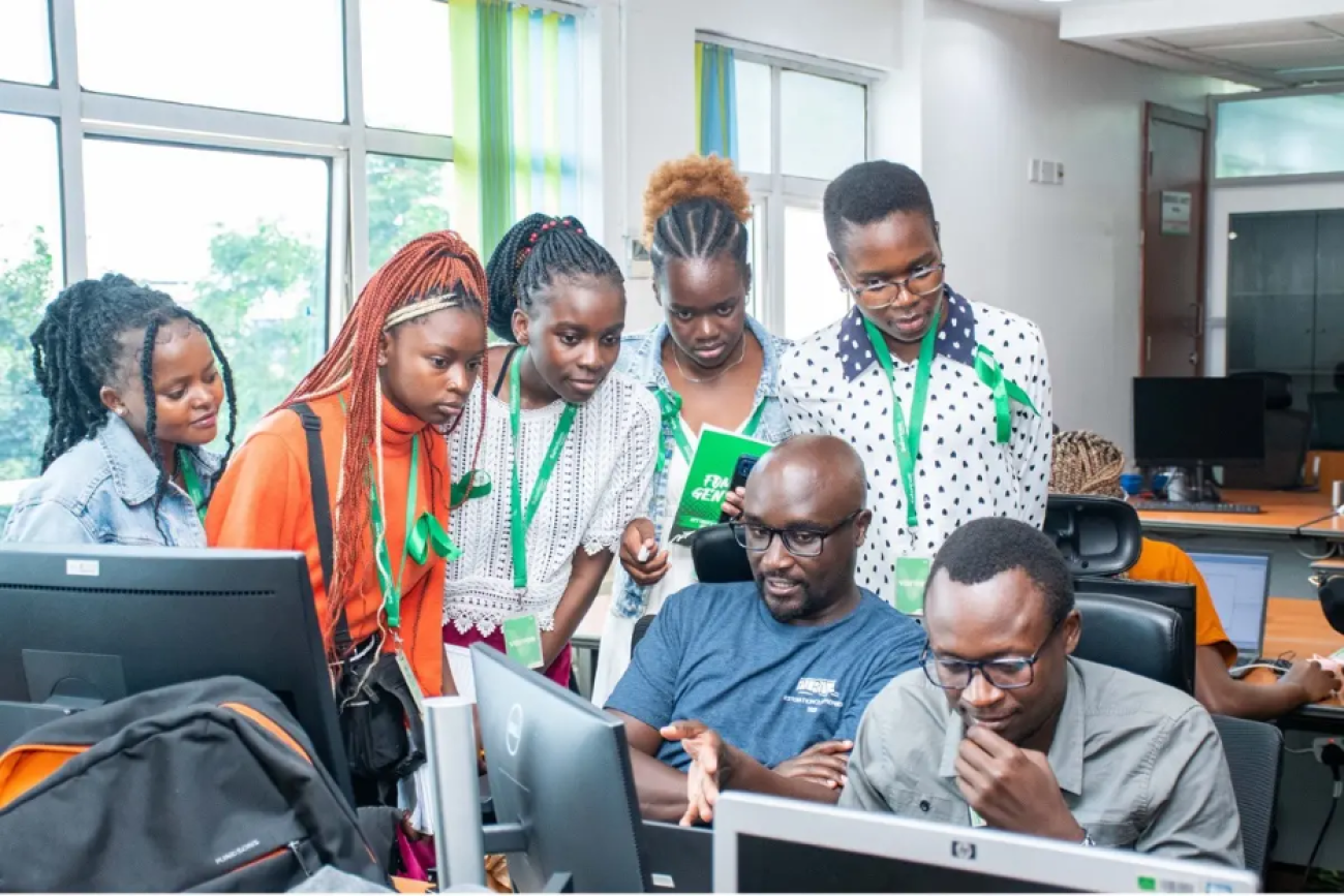 A group of young people gather around a computer in Kenya