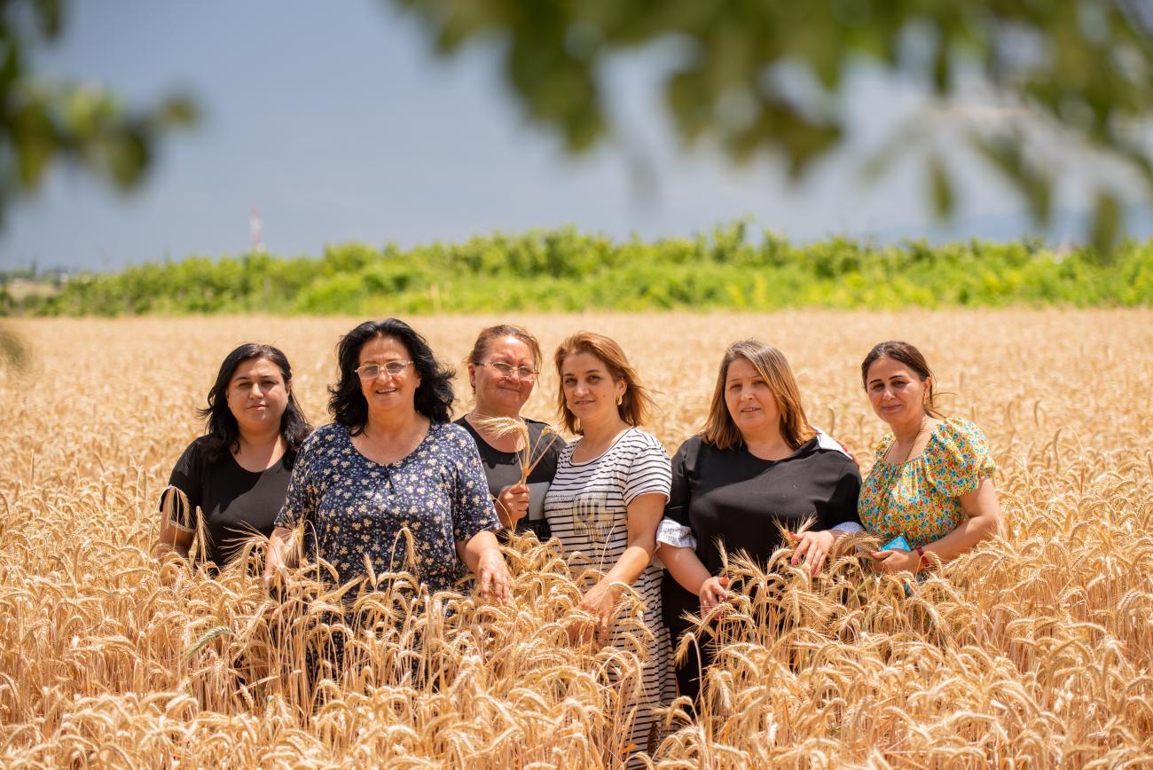 A group of women standing in a field and looking at the camera