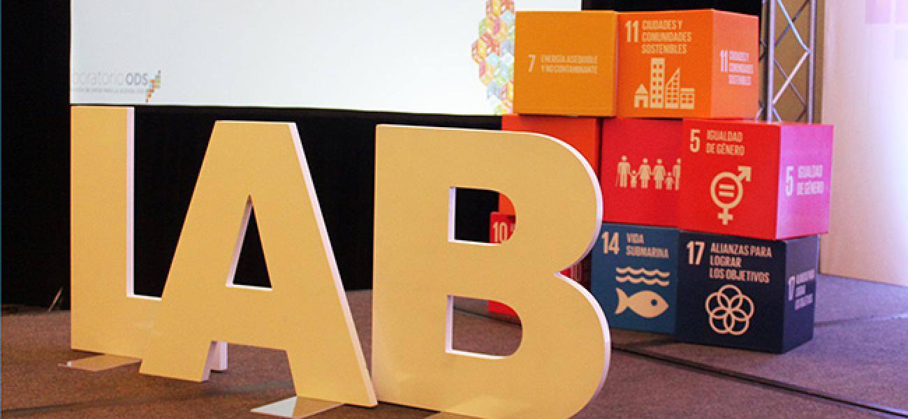 Un escenario con material de utilería en forma de cajas con los ODS , y la palabra "LAB" de laboratorio."