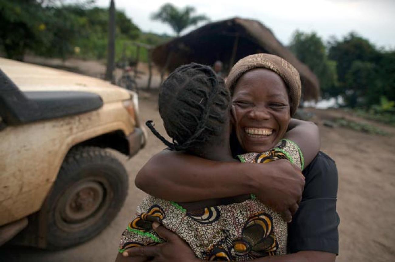 Two smiling people hug. 