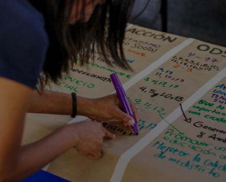 Who We Are section banner showing girl writing notes on poster.