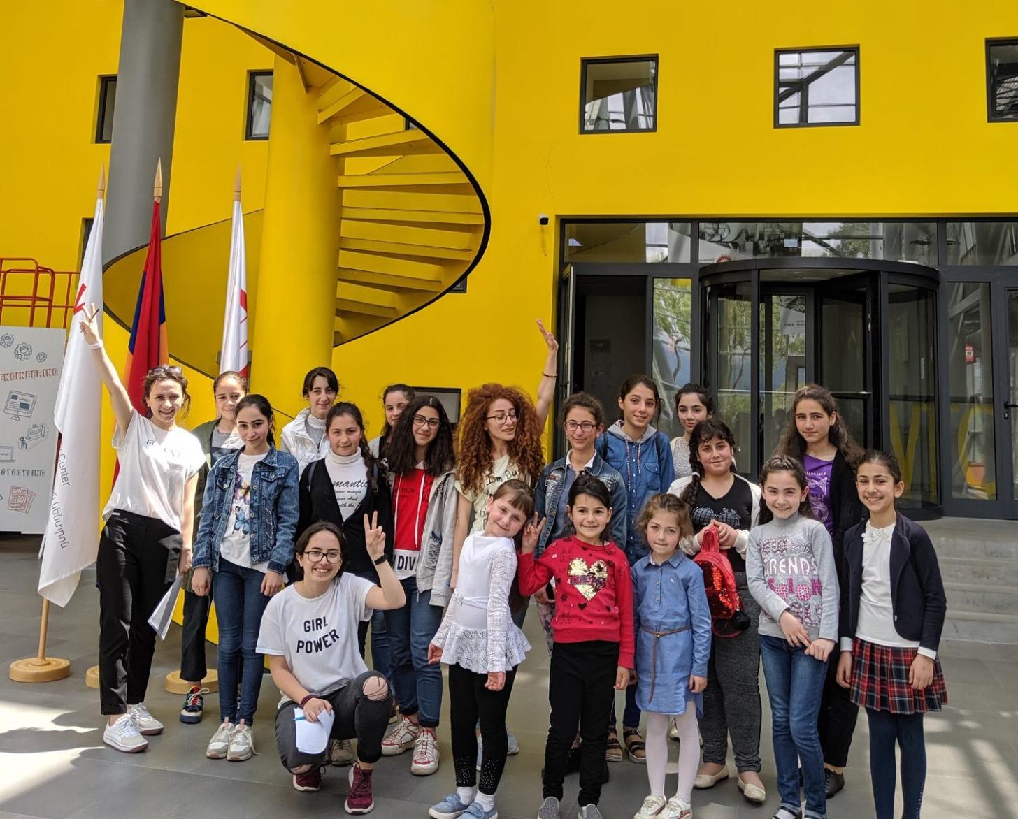 Niñas están de pie fuera del edificio.