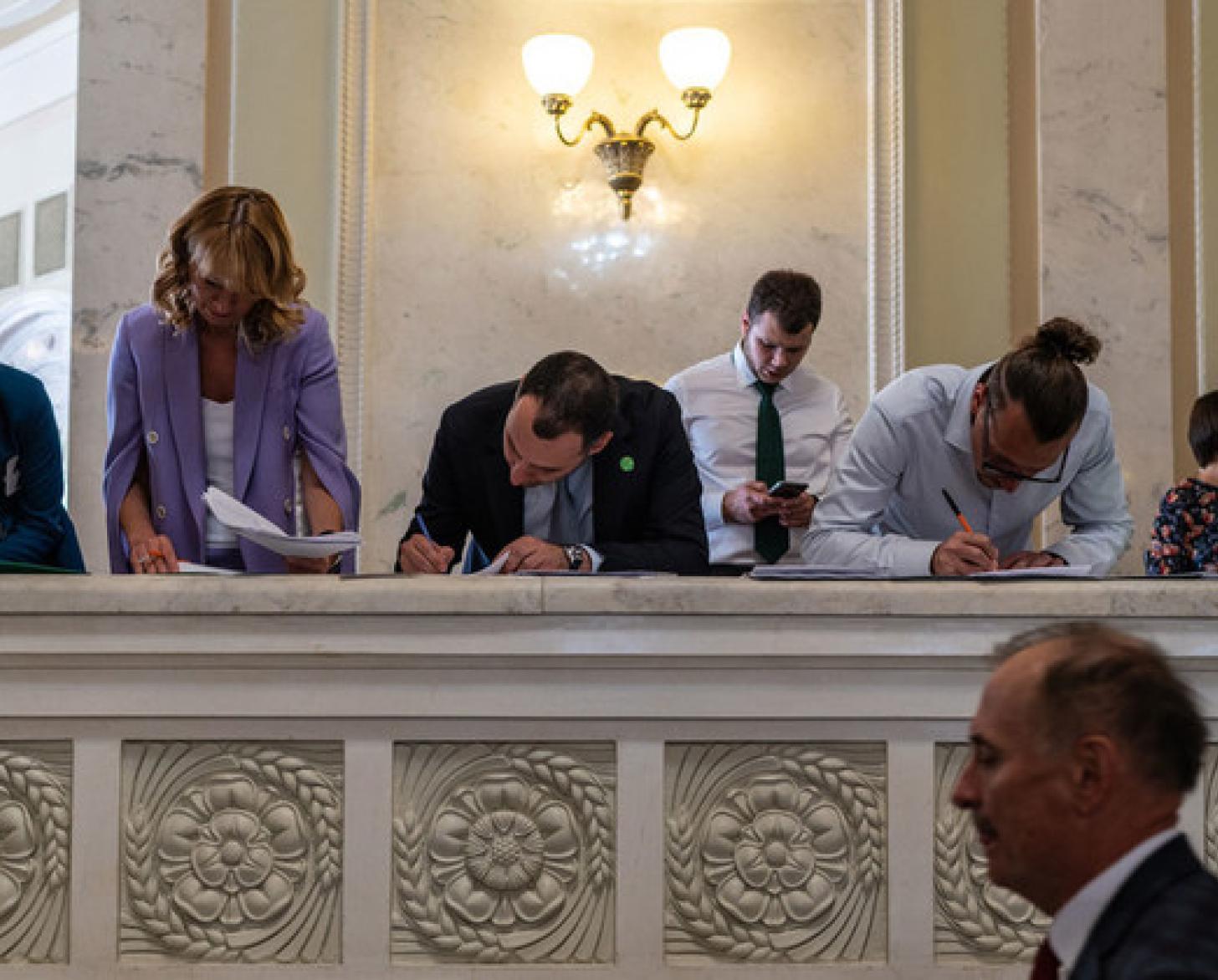 People signing documents in a formal setting