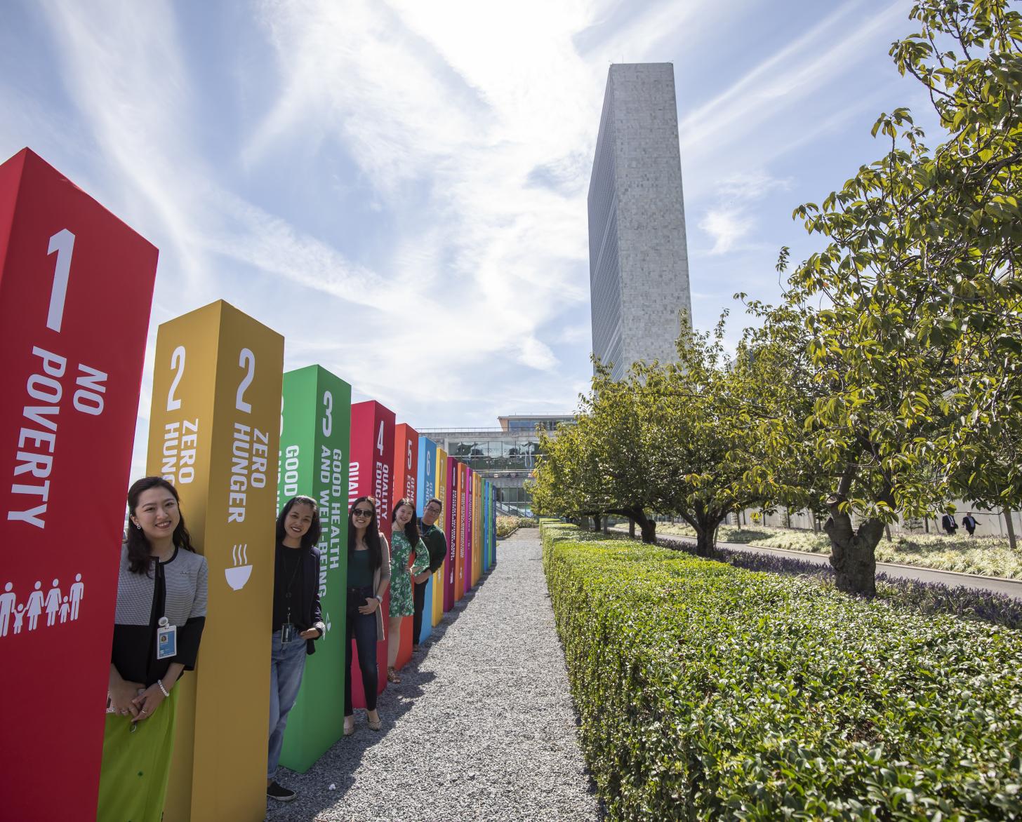 UN Staff members stand outside the SDG Action Zone by SDG pillars.