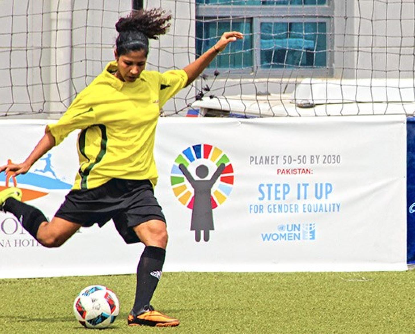 Hajra Khan, team captain of the Female National Football Team of Pakistan, is shown kicking a football during a game.