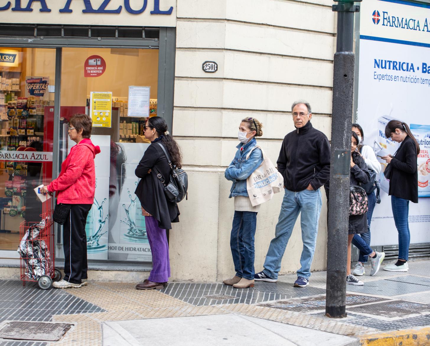 People wait in line outside a pharmacy in Argentina.