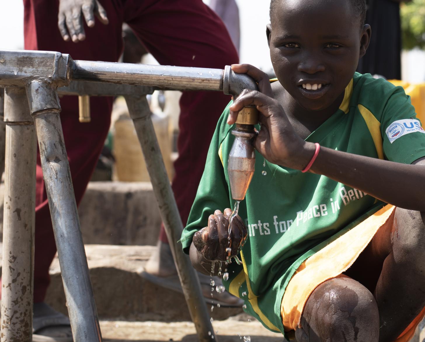Outside the water treatment plant in Bentiu, children are drinking from water kiosk supplied by water treatment plant. 