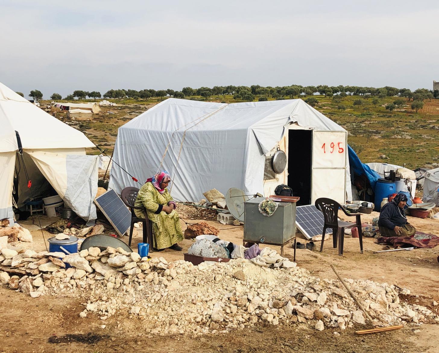 Displaced people sit outside their tents at the Harbonosh Internally Displaced People Camp.