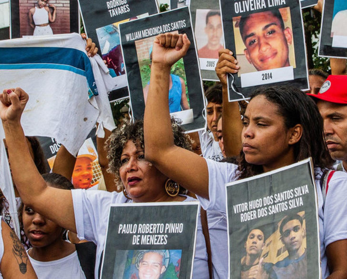 Image shows a group of men and women holding signs of youth who have passed.