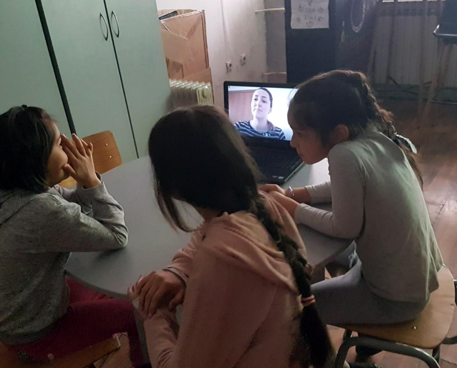 Three young female students participate in an online class.