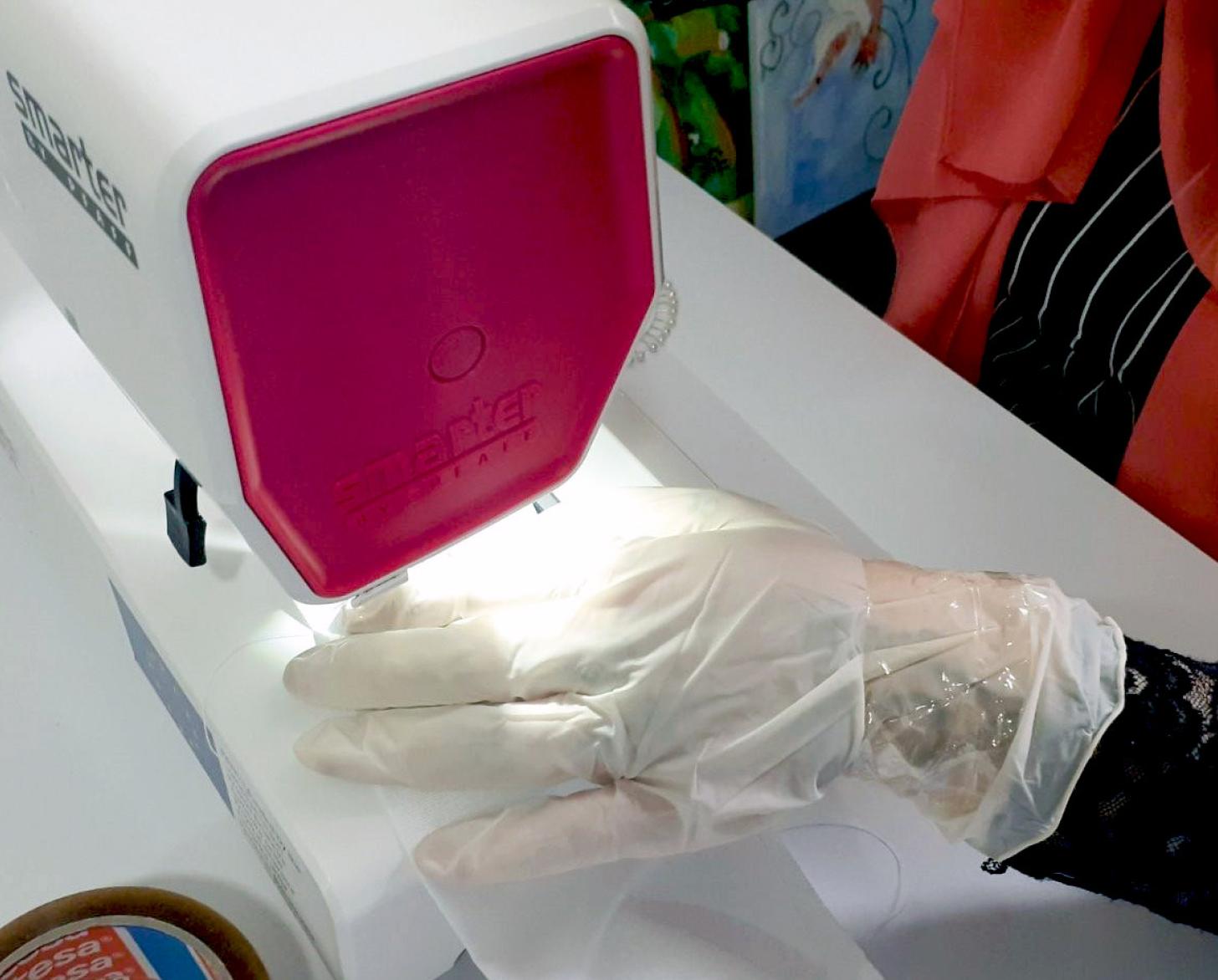 Closeup of hands sewing protective masks.