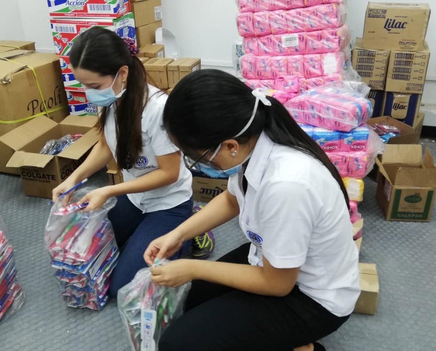 Los cepillos de dientes y las toallas higiénicas se clasifican para empaquetar kits de dignidad para las mujeres en las prisiones y centros de cuarentena.