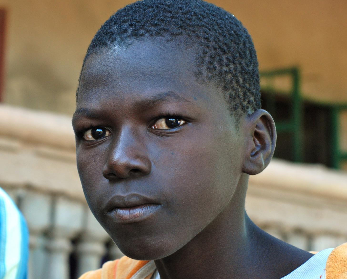 Bubacarr, 15, sits outside his home in Gambia's remote Upper River region. 