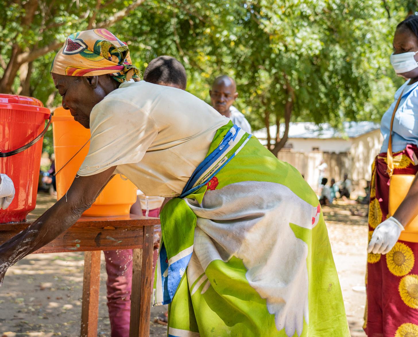 امرأة تغسل يديها في محطات غسل الأيدي في مونا بمنطقة نسانجي (جنوب ملاوي).