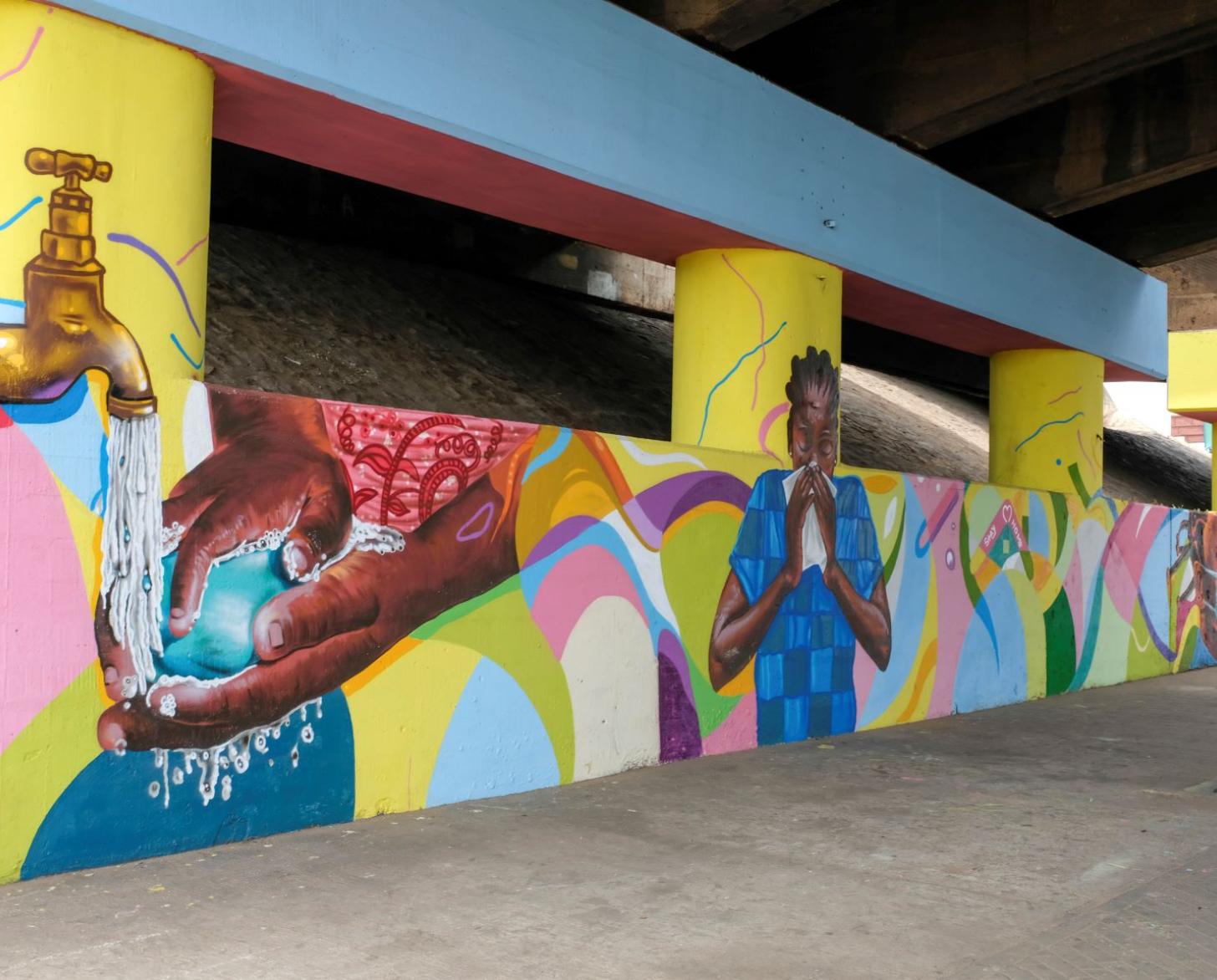 توضح اللوحة الجدارية الزاهية والملونة رسائل الأمل والتضامن، مع التركيز بشكل خاص على حماية المهاجرين.