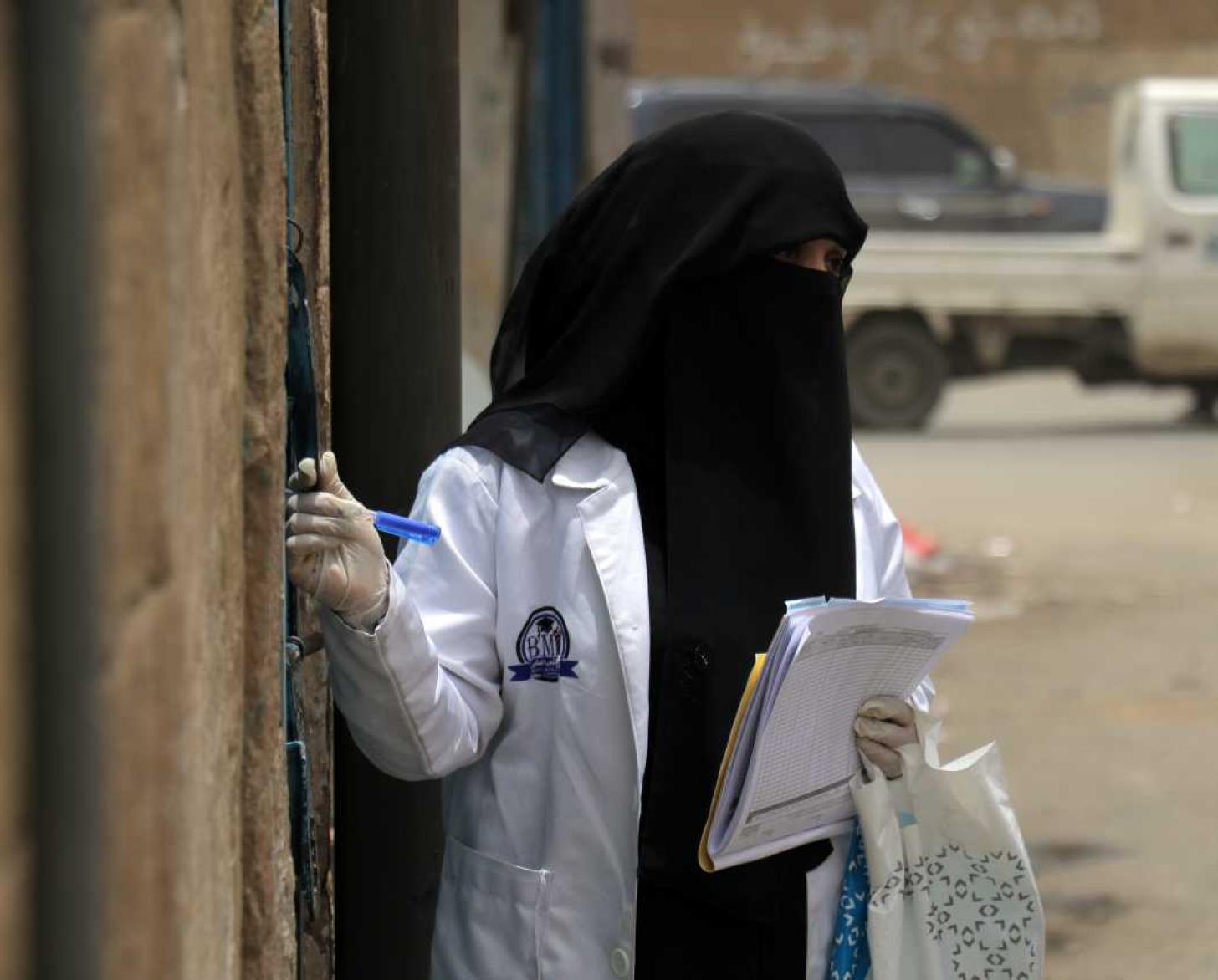 Una trabajadora de la salud está trabajando en las comunidades realizando encuestas casa por casa.