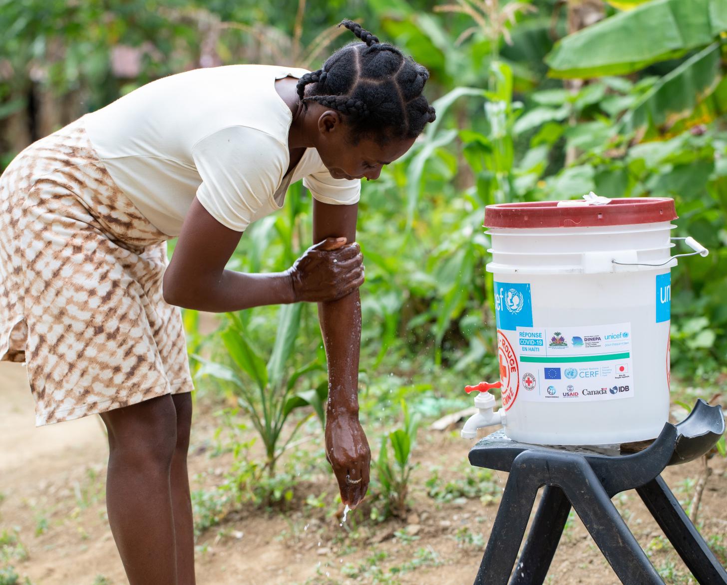 Raymone Notus, 39, washes her hands at a handwashing station in Sevré, Haiti.