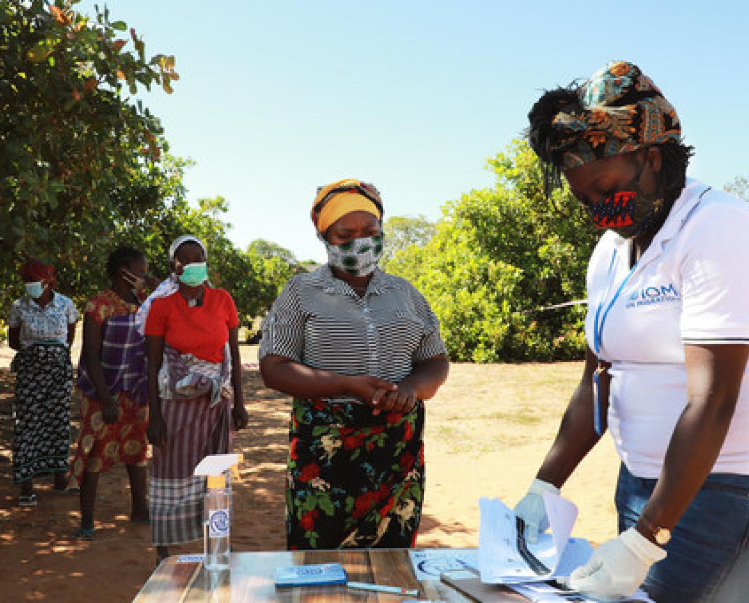 موظفة من المنظمة الدولية للهجرة مع عدد من النازحين داخليًا في مقاطعة كابو ديلجادو.