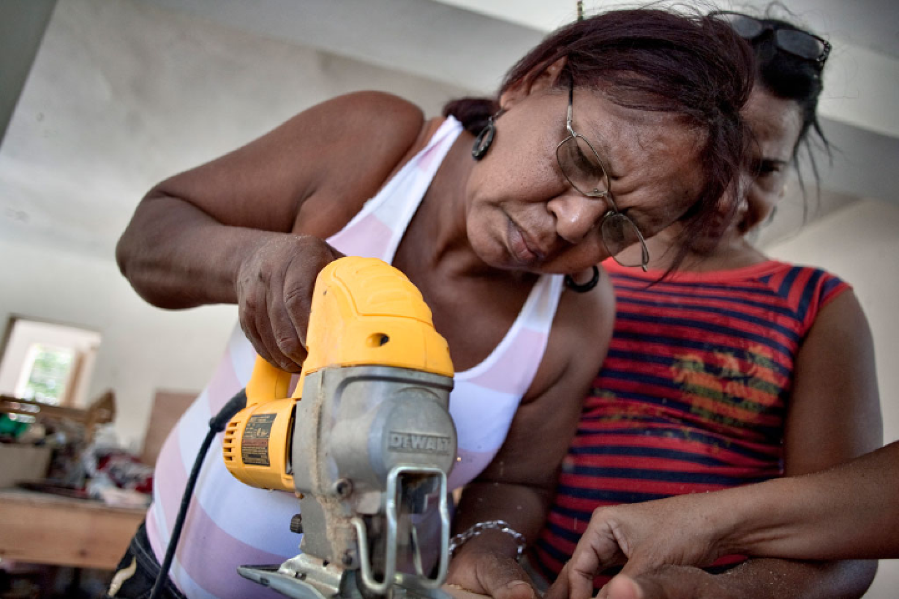 Una mujer utiliza una sierra de mano en el trabajo en un taller de la República Dominicana.