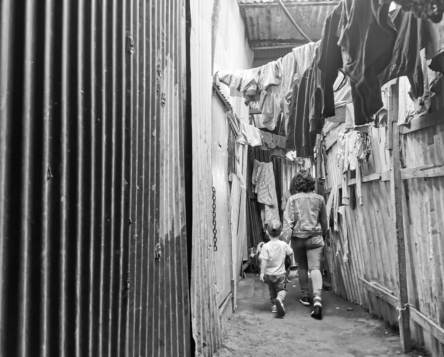 Lilith holds her sons hands as they walk away through a passageway.