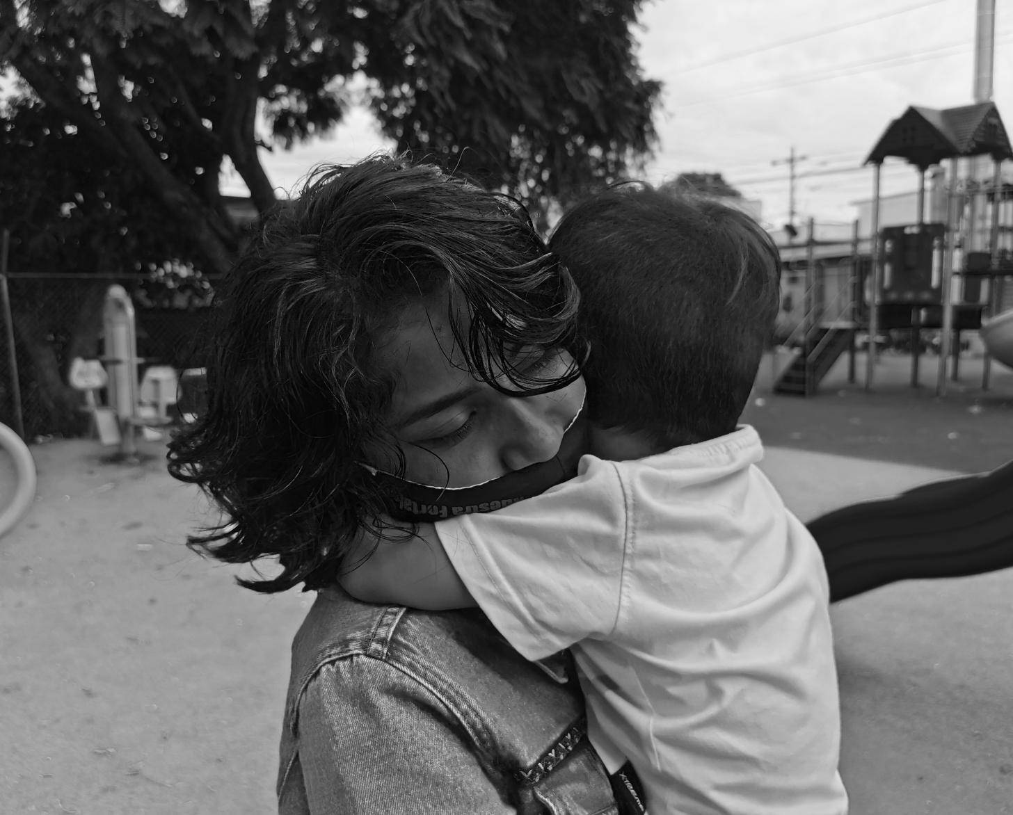 Lilith closes her eyes as she embraces her young son. 