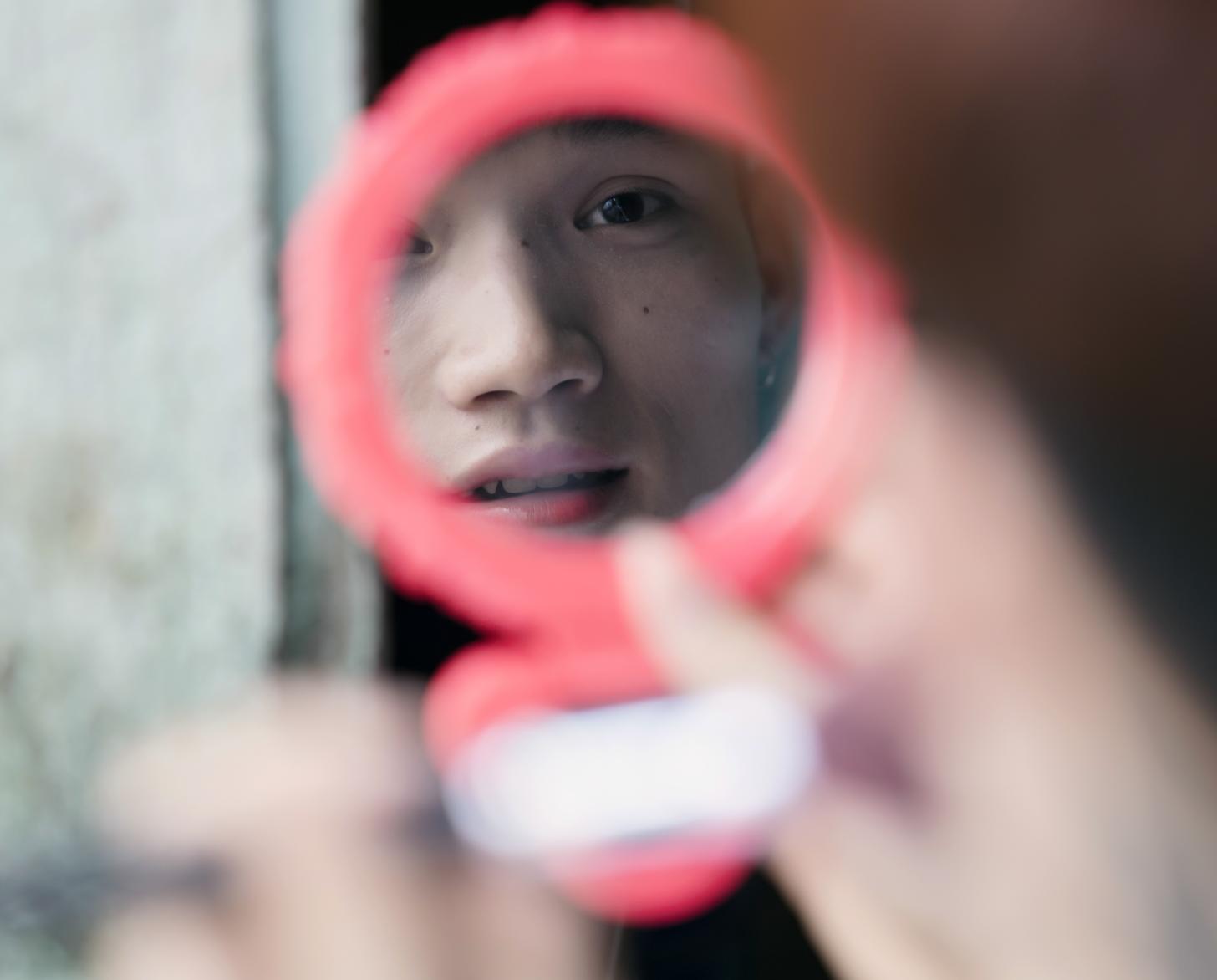 Bui Thi Chi mira su reflejo en un espejo de bolsillo.