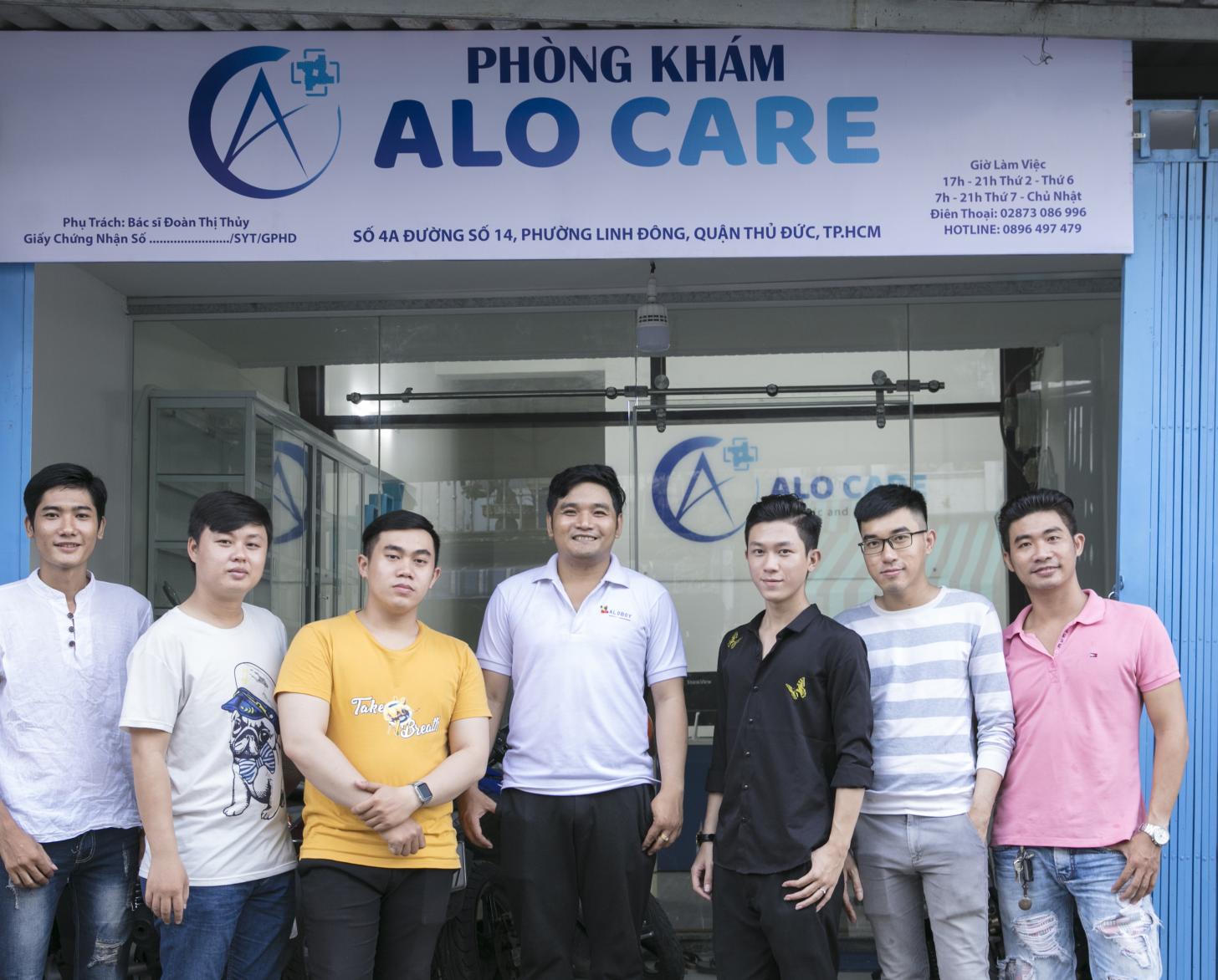 Minh Thuan con su grupo de autoayuda se paran orgullosos frente a la entrada de Alo Care.