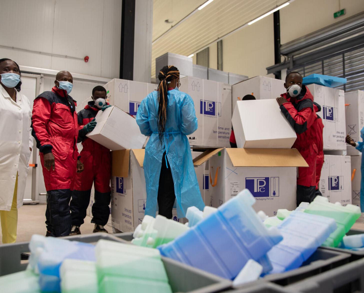 Cold chain staff unpack the COVID-19 vaccines for storage in the cold room.