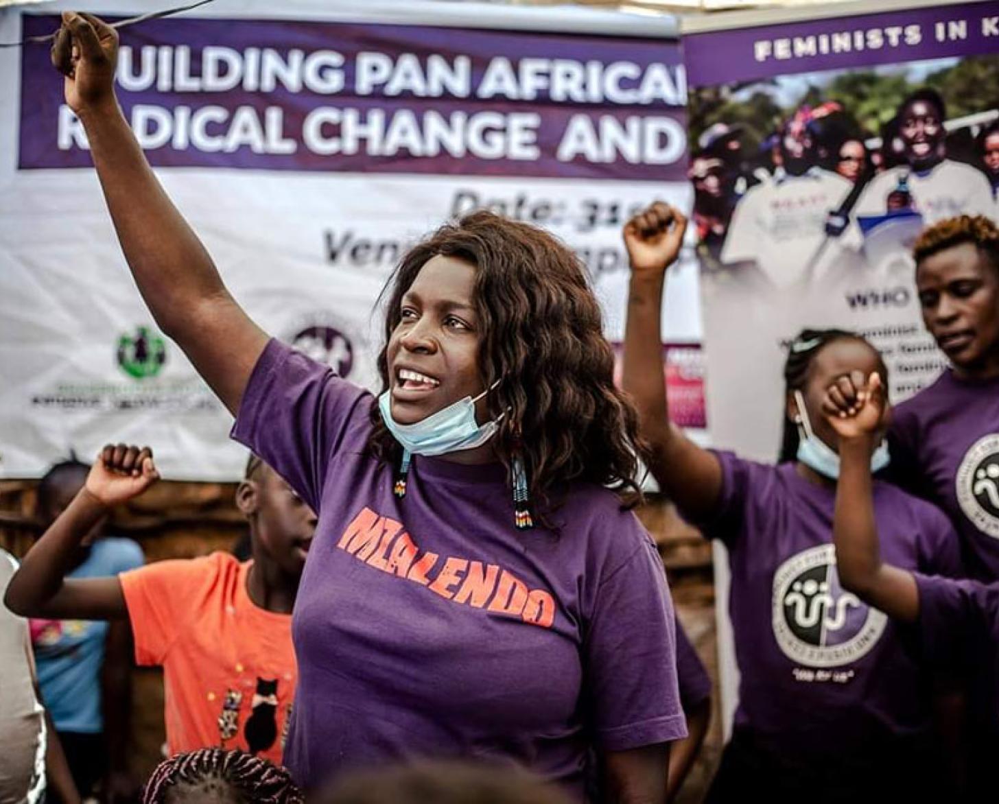 Tres mujeres se sientan juntas al aire libre cerca de una zona de césped con árboles y una escalera.