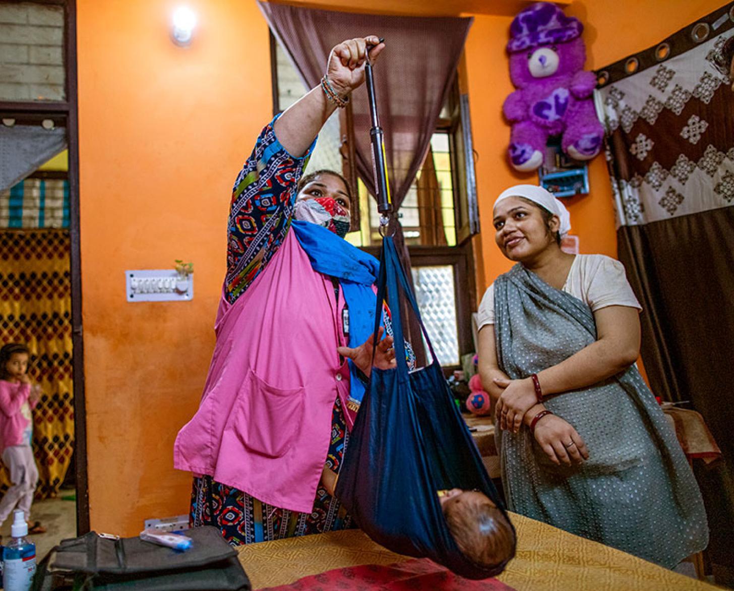 两个妇女给宝宝称重