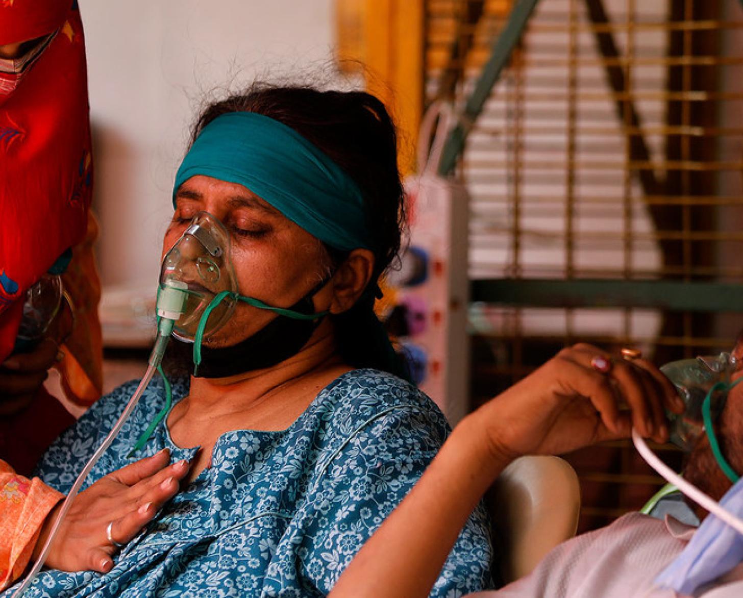 رجل وامرأة مريضان يستخدمان مكثف الأكسجين.