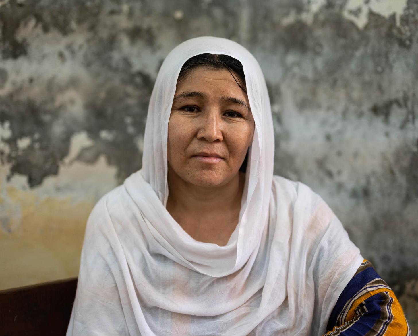 一个戴着白色围巾的女人直视着镜头。