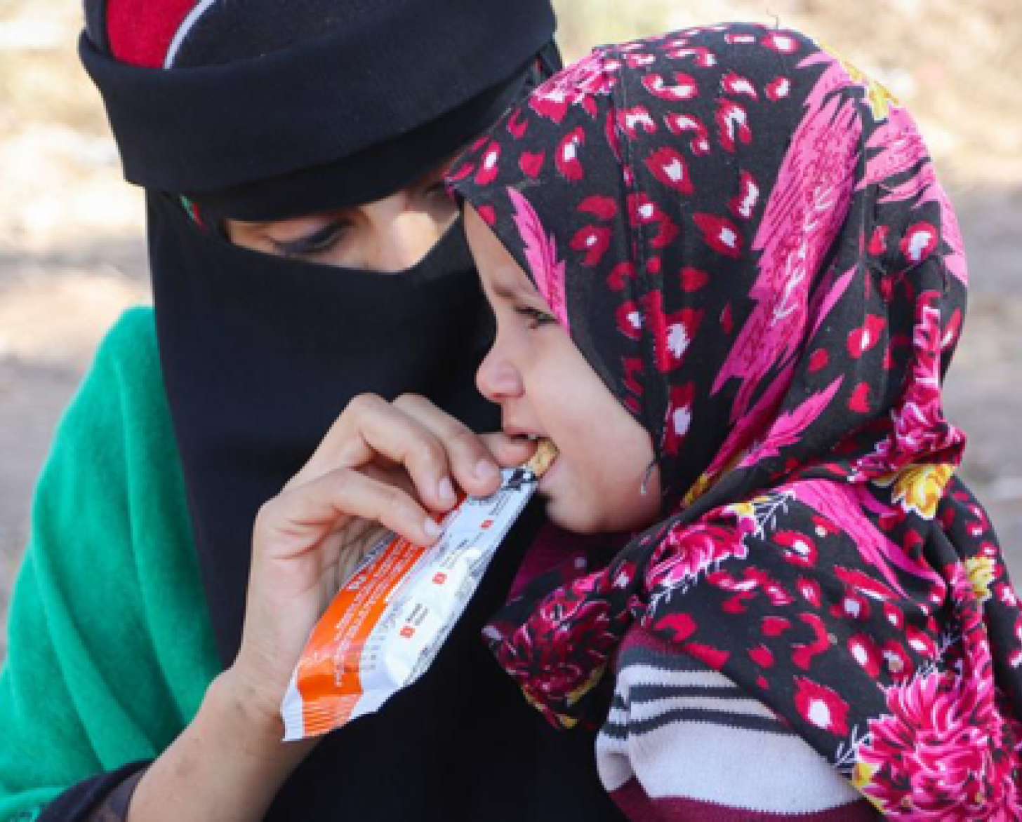 امرأة تطعم فتاة صغيرة وجبة خفيفة مغذية.